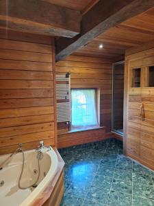 a bathroom with a tub and wooden walls and a window at L'Appart' du Château - Annecy 15 min in Alby