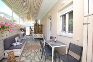 a patio with a table and chairs and a couch at ILIOS apartment in Nydri