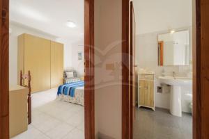a bathroom with a bed and a sink in a room at La Rondine su Seccheto - Goelba in Seccheto +22 photos