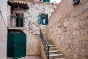 a stone building with a green door and stairs at Apartments Dujam without terrace in Split