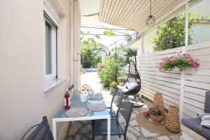 a patio with a table and chairs on a building at ILIOS apartment in Nydri