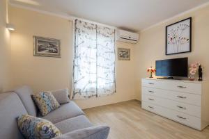 a living room with a couch and a tv and a dresser at Apartments Dujam without terrace in Split