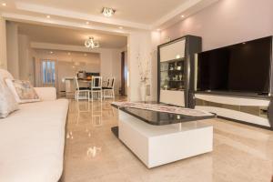 a living room with a white couch and a large television at Villa Seget Large Villa all for you in Seget Vranjica