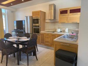 a kitchen with a table and chairs in a kitchen at Central Penthouse Suite BBQ&Hot Tub 5Min Walk2Sea in St Paul's Bay