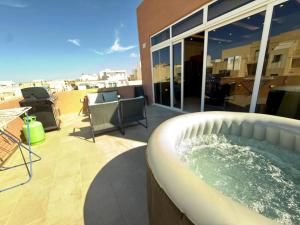 a hot tub on the roof of a building at Central Penthouse Suite BBQ&Hot Tub 5Min Walk2Sea in St Paul's Bay