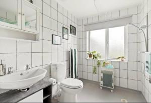a white bathroom with a toilet and a sink at Cozy Dover House with 4 Bedrooms in Dover