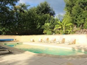 a swimming pool with lounge chairs next to a wall at La Virginie in Rosières