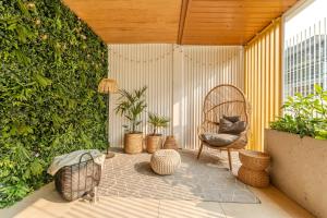 taras z krzesłem rattanowym i roślinami w obiekcie Seaside Loft B009 ze SPA- Posesja Plażowa - Holiday City w Grzybowie
