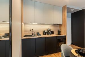 kuchnia z białymi szafkami i zlewem w obiekcie Seaside Loft B009 ze SPA- Posesja Plażowa - Holiday City w Grzybowie +59 zdjęć