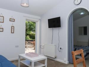 a living room with a blue couch and a table at Little Henford in Beaworthy