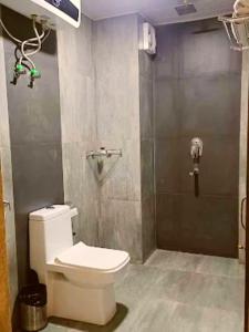 Un baño con inodoro blanco y ducha. en Mirror Hotel, en Gangtok