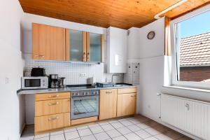 a kitchen with wooden cabinets and a stove top oven at BEGE APARTMENTS Corporate Corner in Recklinghausen