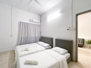 a room with two beds and a mirror at Pearl Cottage - 2min Drive to Lam Wah Ee Hospital in George Town