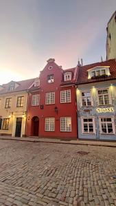 a large red building on a cobblestone street at Stylish Riga Old Town getaway in Riga