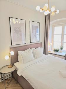a bedroom with a large white bed and a table at Stylish Riga Old Town getaway in Riga