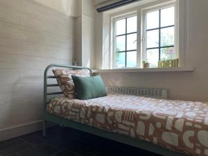 un letto in una stanza con una finestra di Huis van alle winden a Ovezande