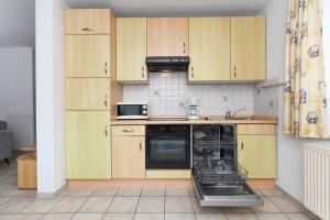 a kitchen with wooden cabinets and a dishwasher at Ferienhaus Pia in Bensersiel