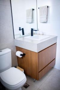 a bathroom with a sink and a toilet and a mirror at Apartamento Loft 02 Lazer Completo in Belo Horizonte +12 photos