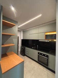 a kitchen with a stove and a microwave at Apartamento Loft 02 Lazer Completo in Belo Horizonte