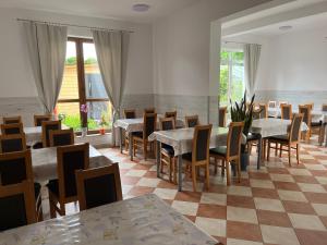 a restaurant with tables and chairs in a room at Pokoje Alina, 500m do morza ze śniadaniem in Grzybowo