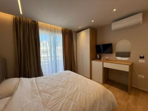 a bedroom with a bed and a desk and a television at Sevians Apartments in Golem