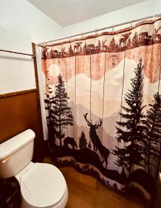a bathroom with a shower curtain with deer on it at The Lodge at Ute Lake aka Yucca Motel and Cabins, Logan, NM in Logan +34 photos