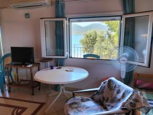 a living room with a table and a window at Greeksummer in Edipsos