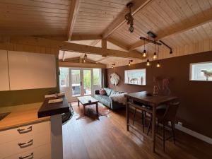 a kitchen and living room with a table and a couch at Schaapskooi in Voorthuizen