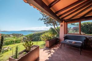 a patio with a bench and a view of the ocean at Villa Ikigai, luxury, sea view swimming pool in Porto Rafael
