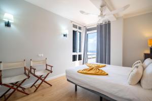 a bedroom with a bed and a chair and a window at Casa Branca Apartments by Wanderlust Madeira, vacation rentals in Funchal +201 photos
