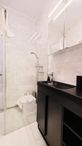 a bathroom with a black sink and a shower at Apartament Szczęśliwy - 14 in Ustronie Morskie