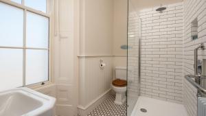 a white bathroom with a toilet and a sink at Cambridge House in Holy Island +20 photos