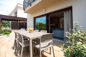 a table and chairs on a patio with a house at VSG Resort - Relaxing Apartments, 200m from the Sea, with Pool, Sauna & Jacuzzi in Klimno