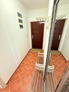 a hallway with two doors and orange tile floors at Cozy apartment with sea view in Petrovac na Moru +5 photos