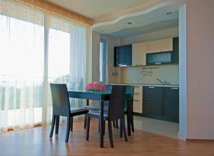 a kitchen with a dining room table and chairs at Nushev Hotel in Sveti Vlas