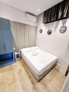 a bedroom with a white bed and a television at Summer Depo in Sarandë