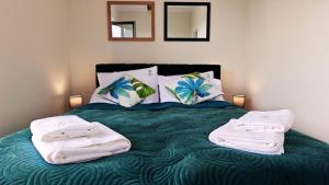 a bedroom with a bed with towels on it at Apartament Szczęśliwy - 14 in Ustronie Morskie