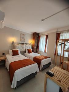 a hotel room with two beds and a table at Aim Bozcaada in Bozcaada