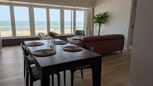 a living room with a table with chairs and a couch at Valdemosa one in De Haan
