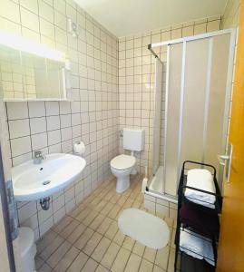 a bathroom with a sink and a toilet and a shower at Sobe-Sandra in Dramalj