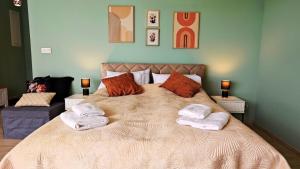 a bedroom with a large bed with towels on it at Apartament Szczęśliwy - 15 in Ustronie Morskie