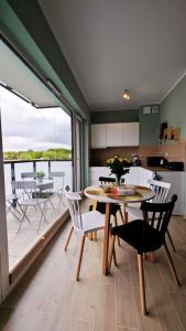 a kitchen and dining room with a table and chairs at Apartament Szczęśliwy - 15 in Ustronie Morskie +14 photos