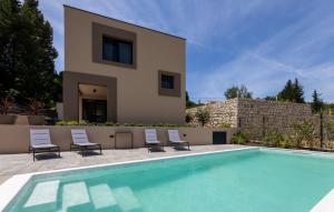 a villa with a swimming pool in front of a house at Villa D Cube by Villas Guide in Kremena