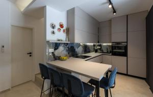 a kitchen with a table and blue chairs at Villa D Cube by Villas Guide in Kremena