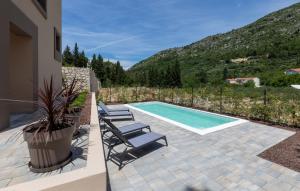 a swimming pool with two lounge chairs next to a house at Villa D Cube by Villas Guide in Kremena