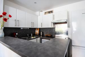 a kitchen with white cabinets and a gray counter top at Large Quiet House, in the city center in Lille