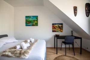 a bedroom with a bed with a desk and paintings at Large Quiet House, in the city center in Lille