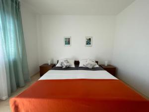 a bedroom with a bed with an orange blanket at Sobe-Sandra in Dramalj