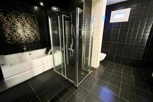 ein Badezimmer mit einer Dusche, einer Badewanne und einem WC in der Unterkunft Family-Friendly Beach Getaway with Jacuzzi-Garden-Resort and Mountain Views in Sharm El Sheikh