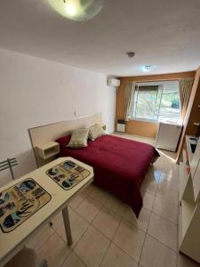 a bedroom with a red bed and a table at Complejo miligamapa con pileta climatizada in Villa Carlos Paz